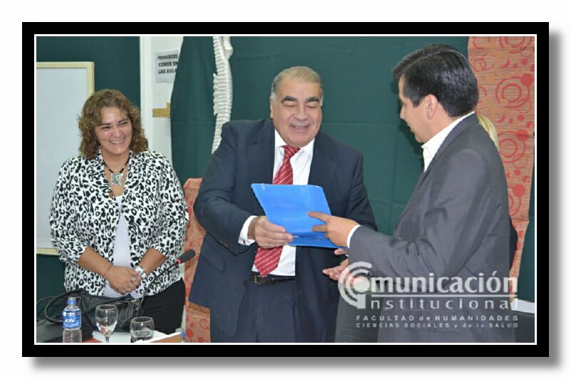 El Vicedecano de la FHCSyS, Lic. Hugo Marcelino Ledesma entrega al Dr. Slosse la resolucin en la que se declara de inters acadmico su conferencia.